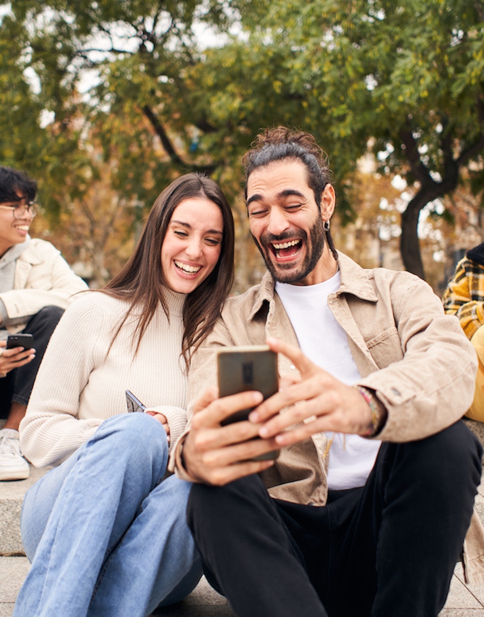 Pareja de jóvenes mirando el móvil