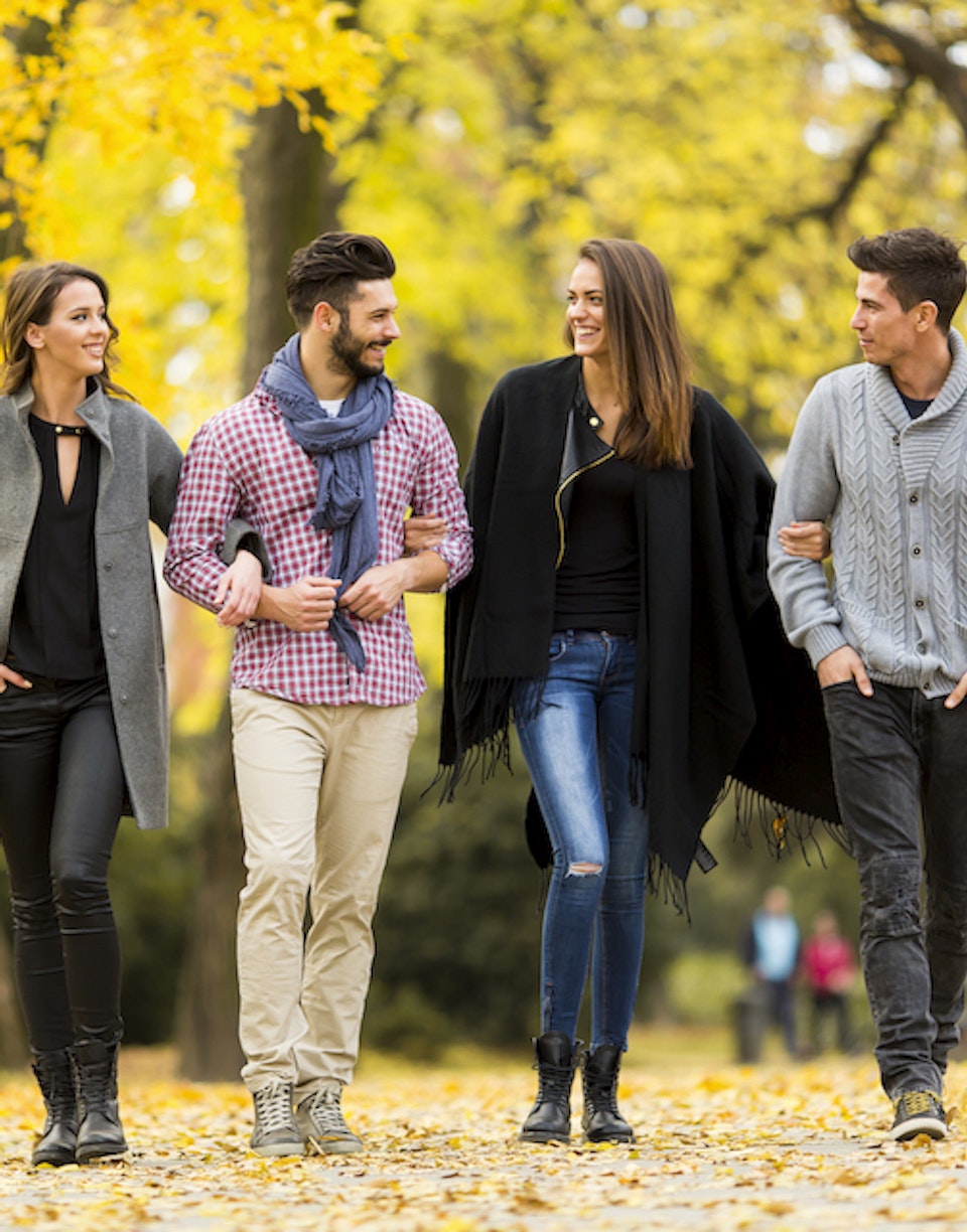 Personas caminando en un parque otoñal