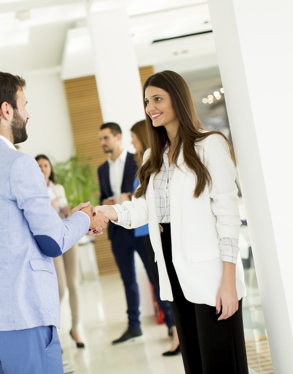 Dos personas se dan un apretón de manos en un contexto empresarial