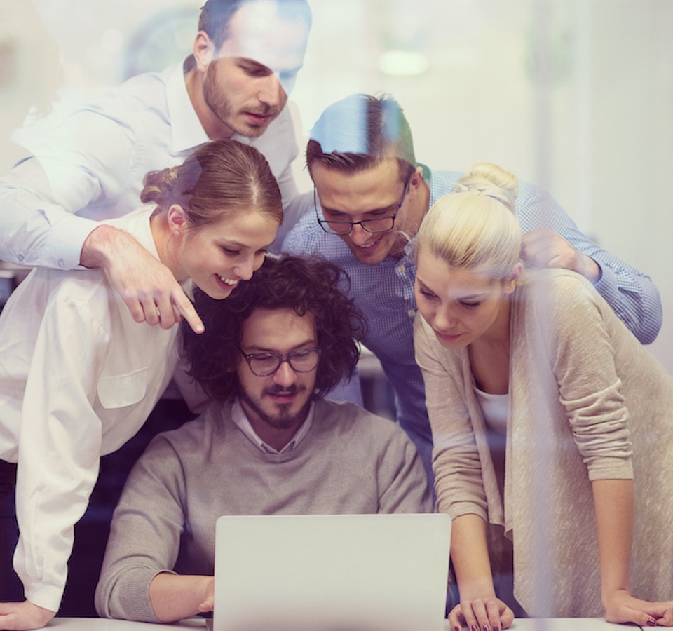 Personas empresarias mirando la pantalla de un portátil en un contexto de oficina.