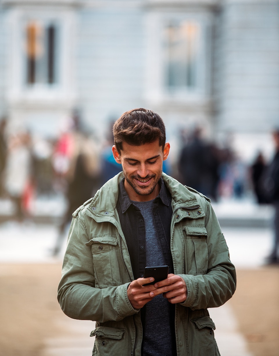 Hombre caminando por la calle mirando el móvil