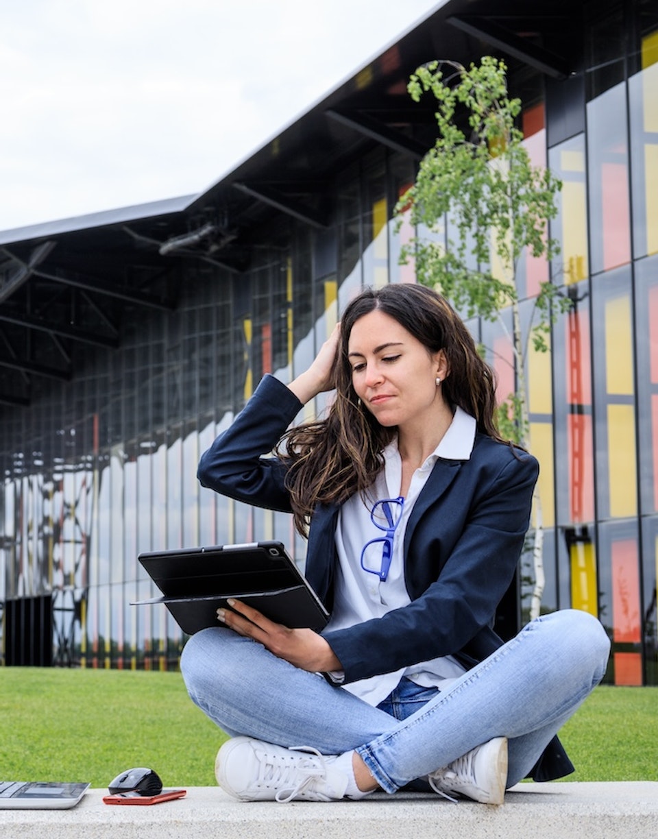 Mujer con un portátil y una tablet en un parque