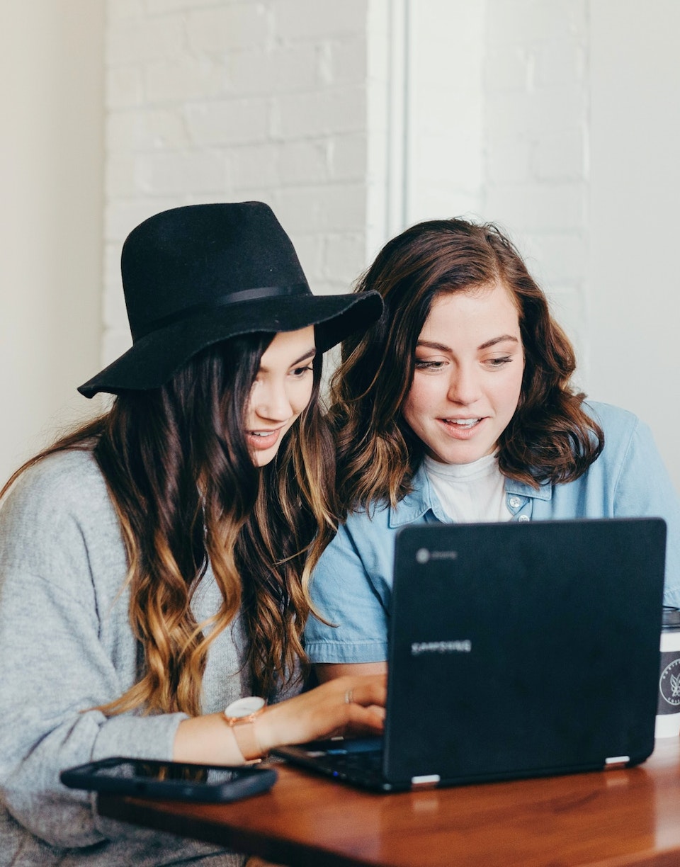 Chicas con portátil y café en oficina